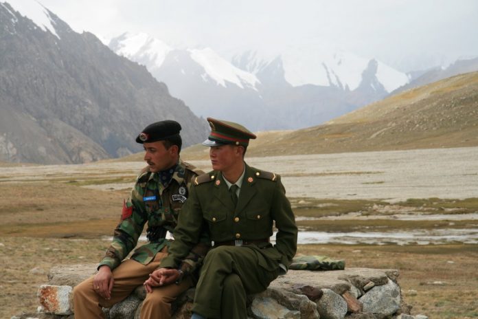Latest news on CPEC | China-Pak Economic Corridor | ThePrint Chinese and Pakistani guards sitting on a rock at the Khunjerab Pass