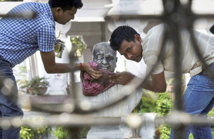 Dr. Syama Prasad Mukherjee's bust vandalized A group of people clean the bust of Bharatiya Jana Sangh founder Syama Prasad Mukherjee after it was vandalised | PTI