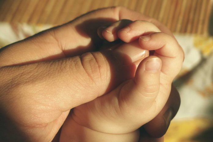 A new born holds fathers hand |Representational Image