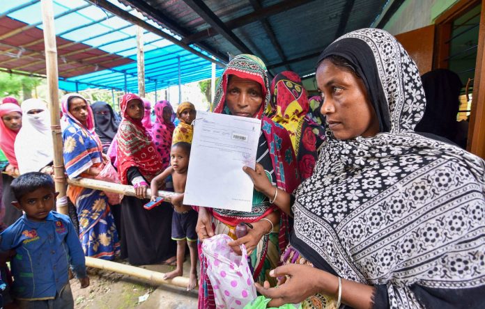 People wait to check their names on the final draft of the state's National Register of Citizens. | PTI