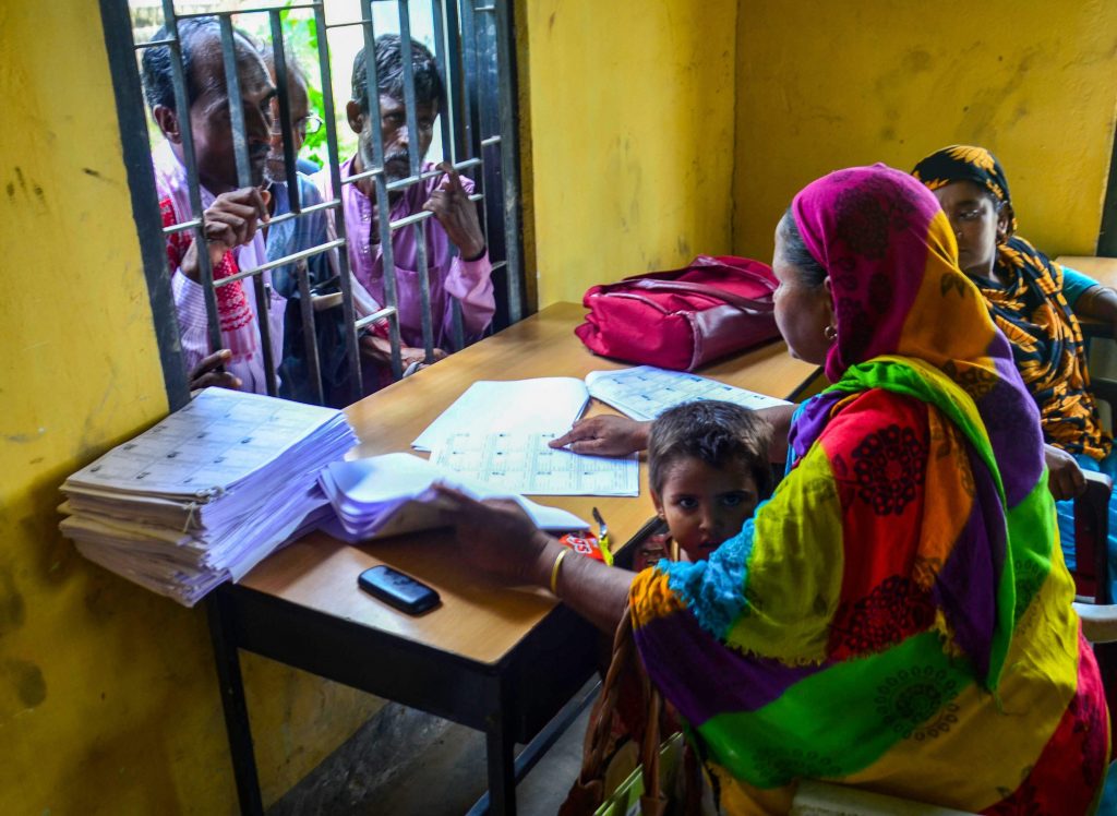 People wait to check their names on the final draft of the National Register of Citizens (NRC) after it was released, at NRC Seva Kendra, Goroimari in Kamrup district of Assam on 30 July 2018 | PTI