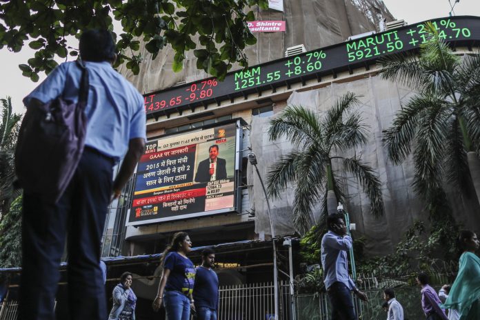 General Economy Ahead Of India's Budget A man looks up at an electronic ticker board that indicates stock figures at the Bombay Stock Exchange (BSE)