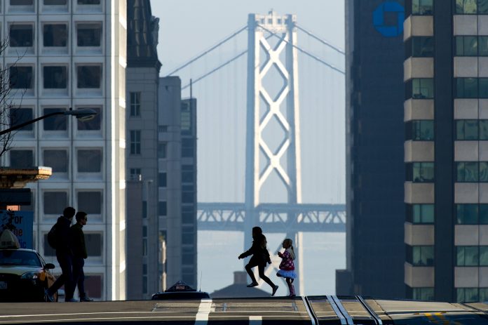 Latest News on economic growth | ThePrint.in Pedestrians cross the street in front of the Oakland-San Francisco Bay Bridge in California | David Paul Morris/Bloomberg