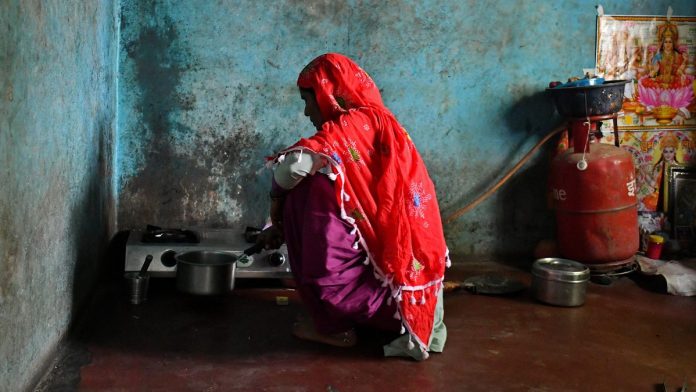 Latest news on Ujjwala scheme and Narendra Modi | theprint.in A woman in Uttar Pradesh cooks on a LPG-connected stove | Anindito Mukherjee/Bloomberg