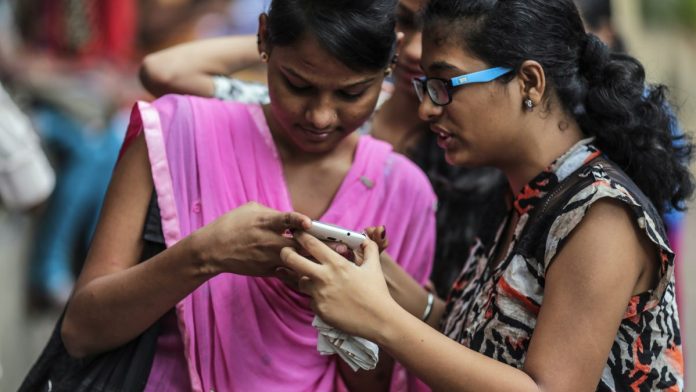 Latest news on women in India and smartphones | theprint.in Women in Mumbai look at a phone | Dhiraj Singh/Bloomberg