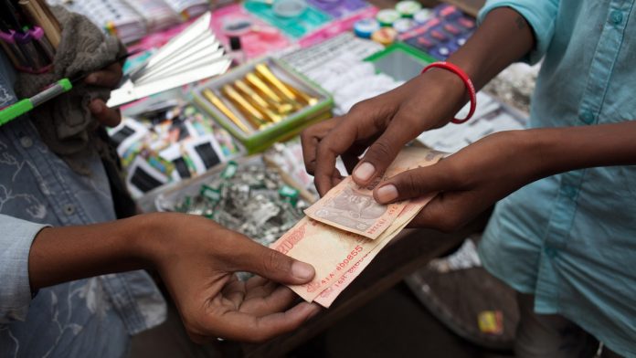 Latest news on Indian Economy | ThePrint A vendor hands Indian rupee banknotes to a customer at a stall in Chauta Bazaar in Surat, Gujarat