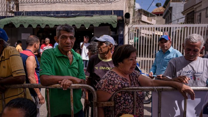 Residents stand in line at a volunteer humanitarian aid camp set up for medical treatments in the Macarao neighborhood of Caracas, Venezuela | Adriana Loureiro Fernandez/Bloomberg