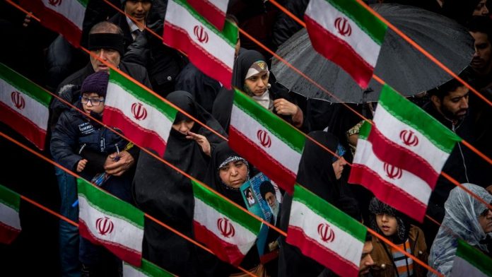 Iranians march beneath Iranian national flag design bunting during celebrations marking the 40th anniversary of the Islamic revolution in Tehran, Iran,| ThePrint