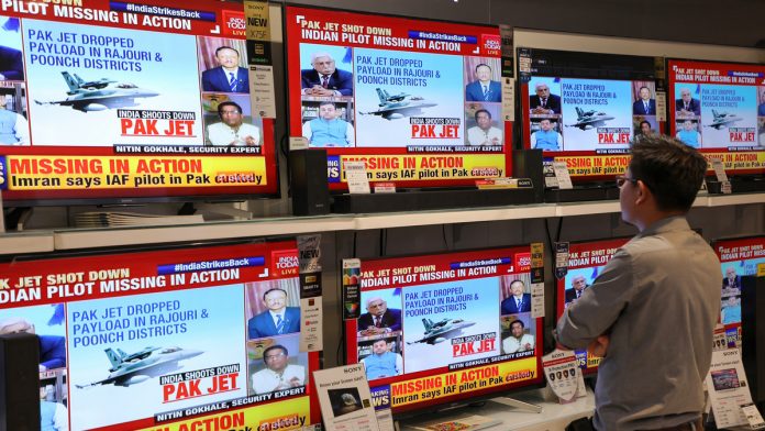 Reactions in Karachi To Pakistan Downing Indian Jets in Worst Escalation Since 1971 War A man watches a television news report in New Delhi|T. Narayan/Bloomberg