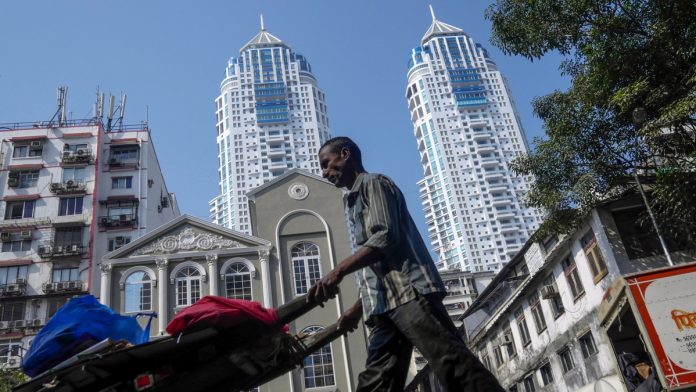 Bankruptcy Law Is Kick Indian Firms Needed to Pay Up, Sahoo Says A man pushes a cart past the Imperial, a twin-tower residential skyscraper complex developed by S D Corp. | Dhiraj Singh |Bloomberg