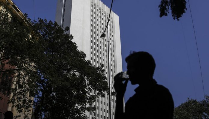 General Economy Ahead Of India's Budget A man drinks tea as he walks past the Reserve Bank of India (RBI) headquarter building in Mumbai