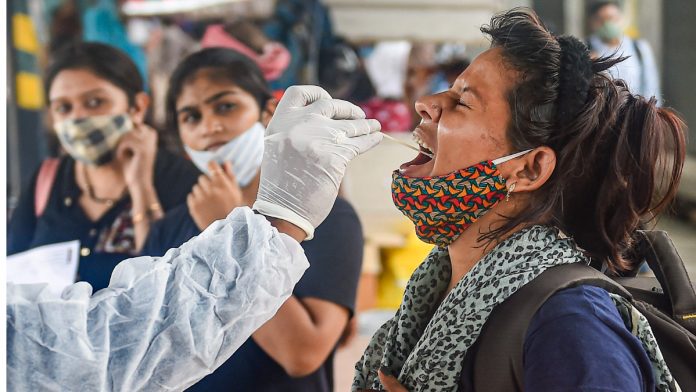 Covid Testing A health worker takes swab sample of a passenger for Covid-19 testing at Dadar railway station in Mumbai on 26 July 2021| PTI